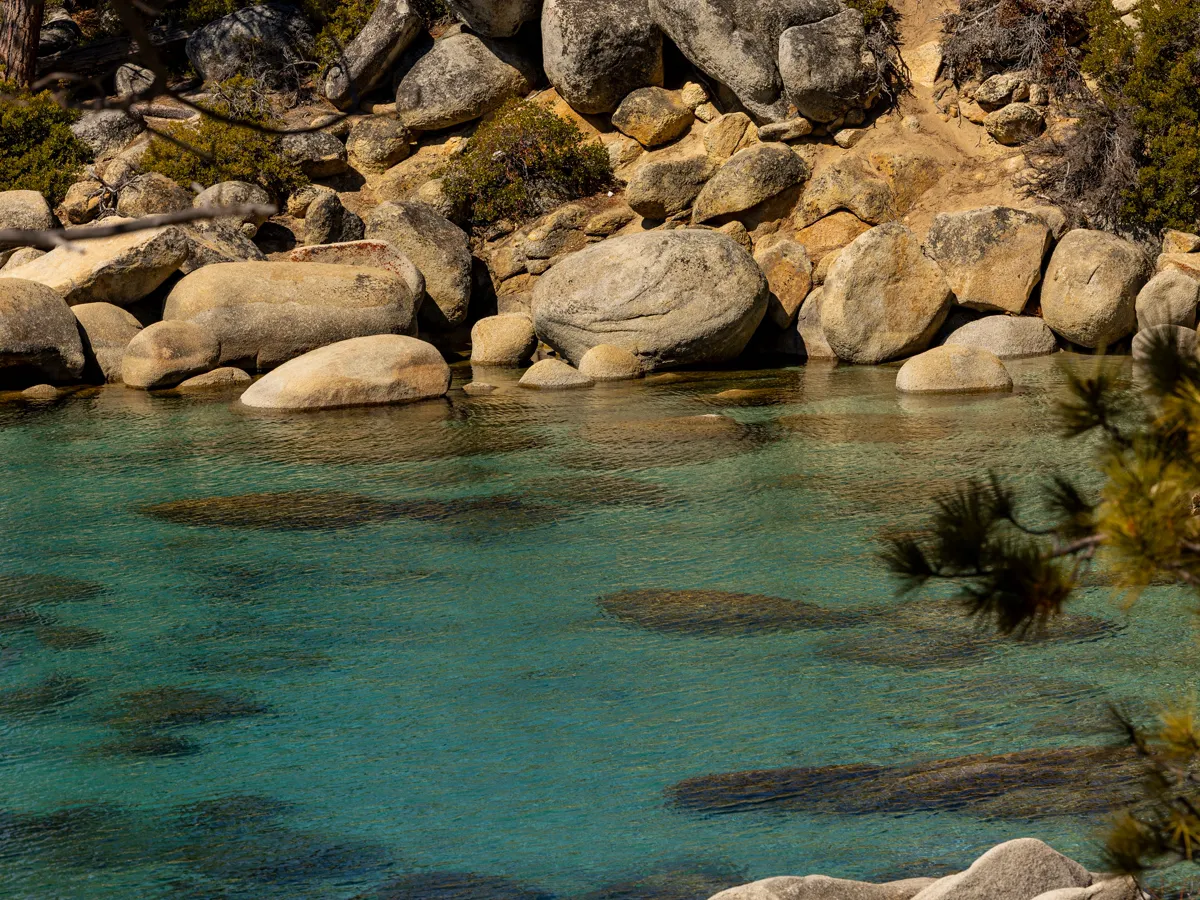 Turquoise shallows of Lake Tahoe's east shore with granite boulders along the shoreline